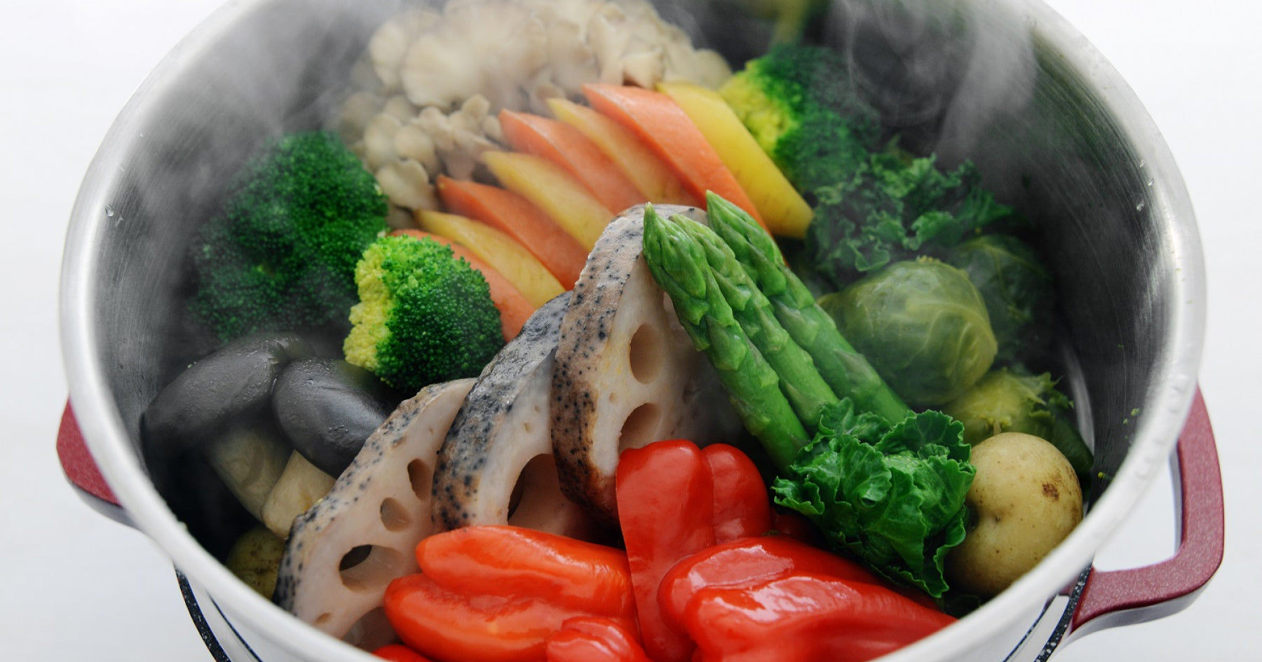 両手鍋の中に、アスパラガスやレンコン、ブロッコリーなどの蒸し野菜が入っている。